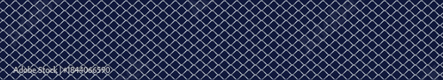 Silver wire mesh fence on a blue background.