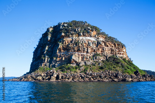 Front view of the iconic Lion Island located at the entrance of the Hawksbury River on the NSW Central Coast. Captured from the water looking west on a blue sky sunny day.