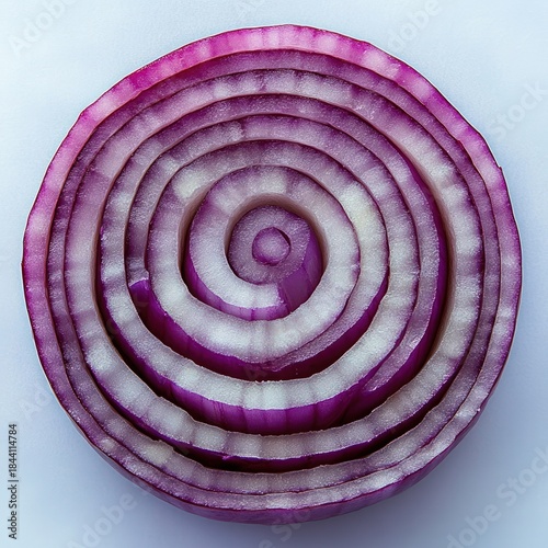 Close-up of a cross-section of a purple onion showing concentric rings with translucent white and vibrant purple layers on a light background