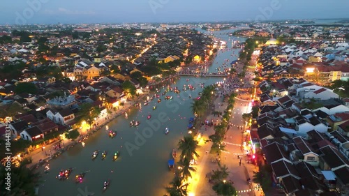 aerial drone of Hoi An Ancient Town, Vietnam, during sunset Traditional colorful lanterns illuminate the Thu Bon River and historic houses, highlighting the UNESCO World Heritage site