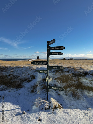 Directional sign and the iconic Bárður Snæfellsás Statue, a landmark on the Snæfellsnes Peninsula, with sweeping views of the ocean, mountains, and dramatic coastal cliffs in western Iceland.