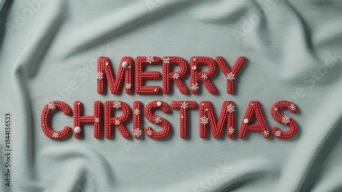 Red and white text spelling 'Merry Christmas' on a soft, light blue fabric background. The letters are decorated with snowflakes and a festive design.