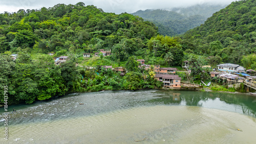 Scenic view of vibrant nature and houses along the riverbanks in Agua Clara, Valle del Cauca, Colombia.