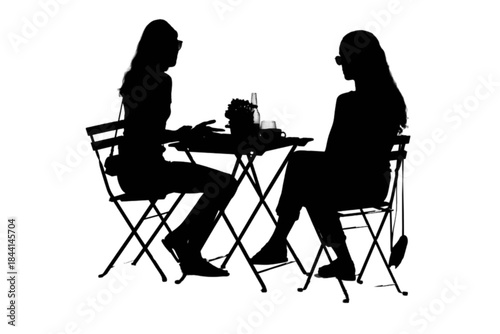 Two young women enjoying coffee at an outdoor cafe on a sunny day.