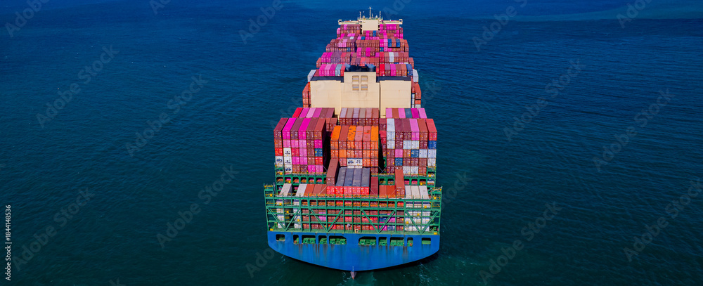 Fototapeta premium container ship, fully loaded with goods, sails out to sea, delivering products to various locations