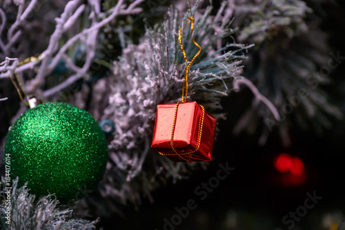 Close-up of a beautifully decorated ornament hanging on a artificial Christmas tree.