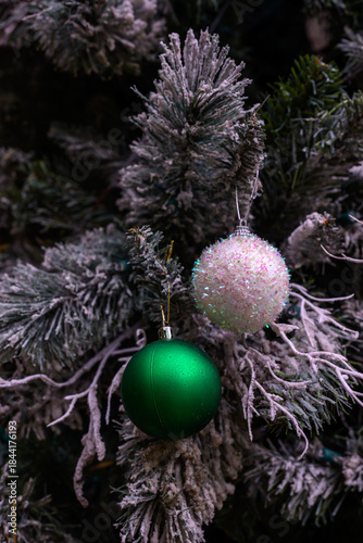 Close-up of a beautifully decorated ornament hanging on a artificial Christmas tree.