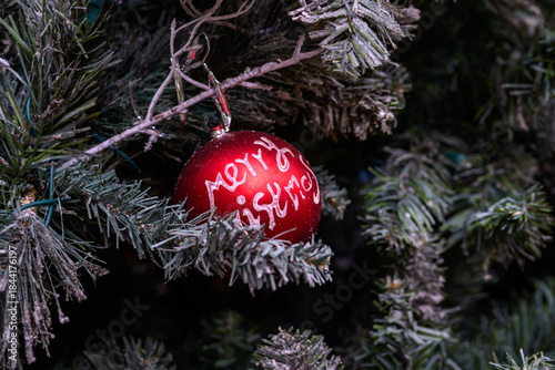 Close-up of a beautifully decorated ornament hanging on a artificial Christmas tree.
