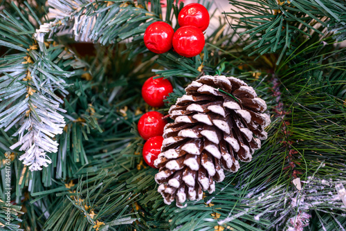 Close-up of a beautifully decorated ornament hanging on a artificial Christmas tree.