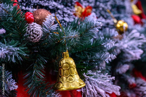 Close-up of a beautifully decorated ornament hanging on a artificial Christmas tree.