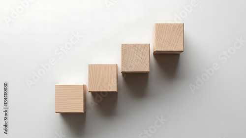 Four wooden blocks arranged in a rising staircase pattern on a light surface