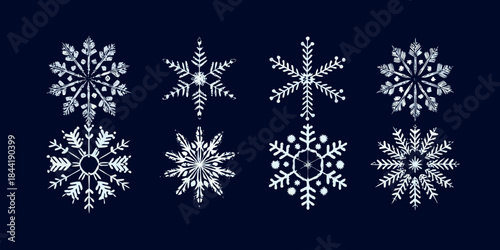 A collection of delicate white snowflakes against a dark blue background