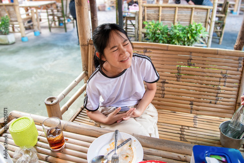 Obraz na płótnie The little girl was eating at a bamboo table, whining because she was hungry