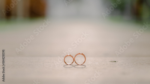 wedding rings on a wooden base with a wedding altar background