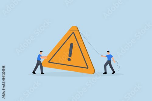 Attention message, businessman pushing exclamation triangle attention sign.