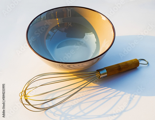 Magnifying glass examining an empty metal dish and business utensil on a table