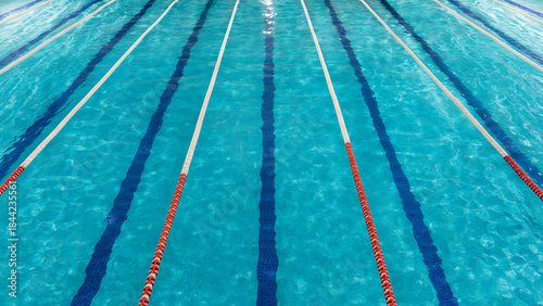 Empty swimming pool lanes with clear blue water, top view background texture