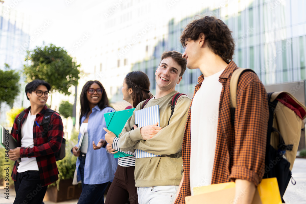 Fototapeta premium Happy university students walking and talking on campus