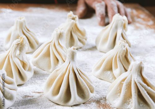 Chef cook making khinkali  on wooden table. Process preparation georgian meal. food concept.