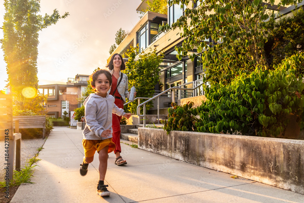 Fototapeta premium Happy child running in vancouver with mother at sunset