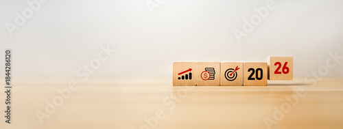 Wooden blocks displaying business growth icons, financial savings symbols, a target goal, the year 2026, representing future planning, economic strategy, investment forecasting, long-term objectives.