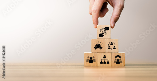 Photography Wooden blocks arranged in a pyramid with icons representing teamwork, collaborat