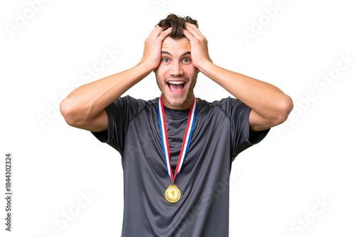 Young caucasian man with medals over isolated background with surprise expression