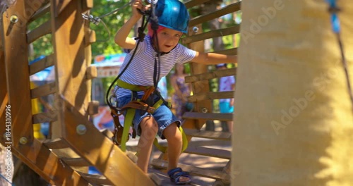 Child Navigating Adventure Park Obstacle Course with Safety Gear