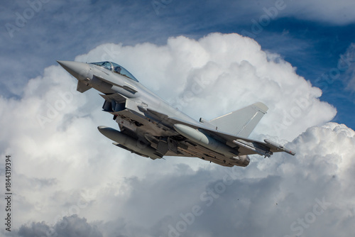 Aviación militar. Avión militar despegando con nubes de fondo