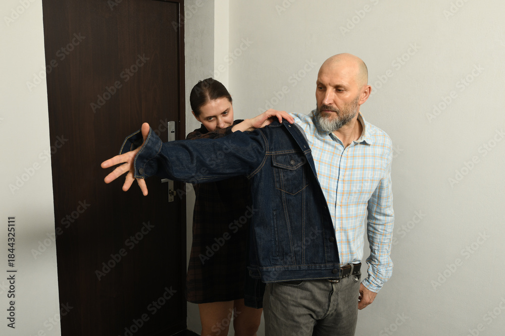 Obraz premium Man and woman in casual clothing hurriedly prepare for an outing in a stylish, modern setting