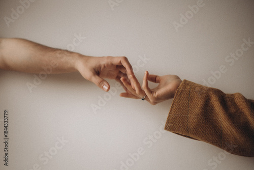 Minimalist shot of two hands reaching toward each other against a neutral background, symbolizing connection, love, and support with a soft, aesthetic and emotional mood.