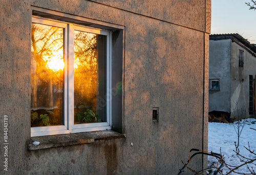 Obraz na plátně Residential house window reflecting winter sunset on concrete facade during cold