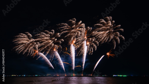 Amazing beautiful colorful firework display over sea on celebration night. Fireworks show for happy new year	