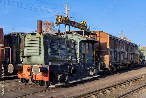 Tableau sur toile Historical green diesel shunting locomotive connected to a rusty brown cargo wagon stationed at the Veluwsche Stoomtrein Maatschappij museum