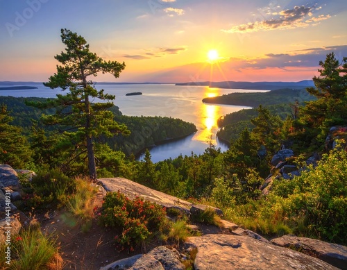 Scenic sunset view overlooking a lake and forest from a rocky mountain top