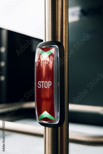 Bus stop request button with indicator lighting and raised tactile markings for accessibility.