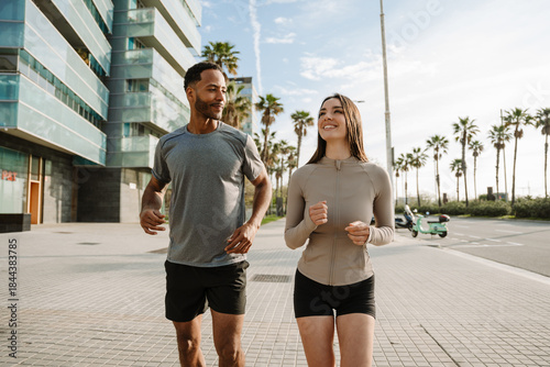 Canvas-taulu Male athlete listening to smiling female athlete while they run