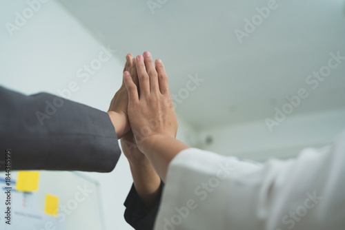 Obraz na plátně Close up of business people giving high five, teamwork success concept, celebration, achievement, collaboration, motivation and positive corporate culture