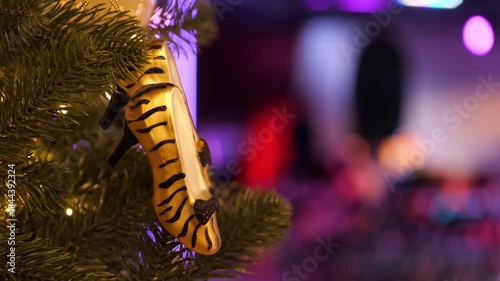 Holiday Elegance. High-Heel Shoe Ornaments on a Christmas Tree Against the Glow of Nightclub Lights