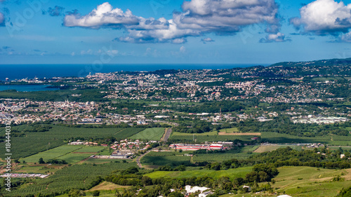 aerial view across green Martinique landscape with city of Fort-de-France next to Fort-de-France Bay, agricultural land and gently rising terrain, Lesser Antilles, Caribbean