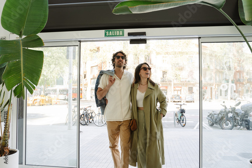 Foto A woman hugs a man as they enter a establishment and talk