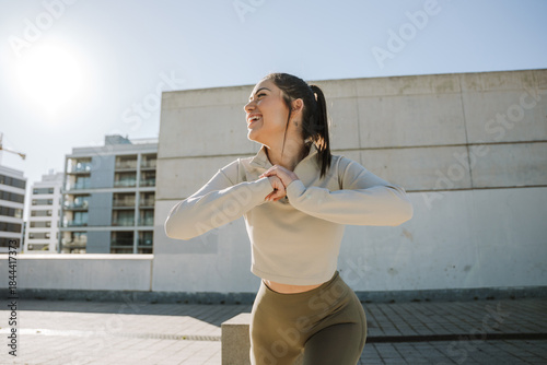 Fotografi Woman lunges and laughs while holding hands together in front of her and looking