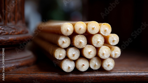 Bundle of thin church candles on wooden surface, religious worship concept, faith and prayer, sacred ritual supplies, orthodox tradition, spiritual devotion and church interior detail with copy space