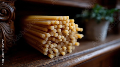 Bundle of thin church candles on wooden surface, religious worship concept, faith and prayer, sacred ritual supplies, orthodox tradition, spiritual devotion and church interior detail with copy space