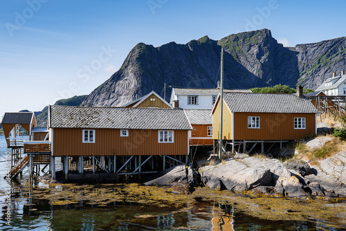 Orange wooden fishermans sheds in Norway under summer light