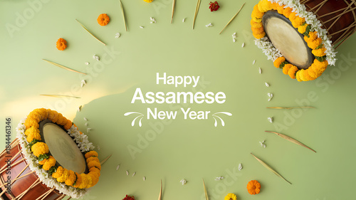 Celebratory arrangement for Assamese New Year with traditional drums and floral decorations on a green background