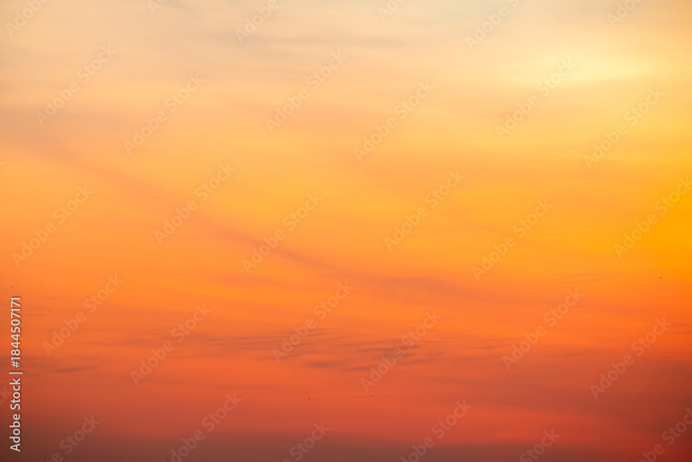 Obraz premium Sunset or sunrise sky with a vibrant gradient of orange, gold, and soft blue. Clear atmosphere with wispy clouds. Peaceful, natural light background. hope, freedom, new day and inspirational Concepts