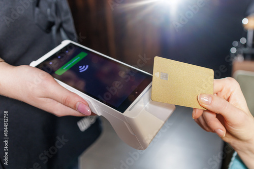Valokuva Close up NFC contactless card transaction with portable POS terminal in restaura
