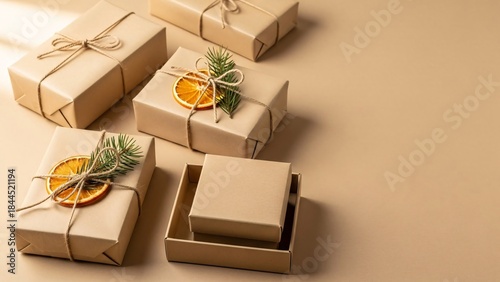 Minimal eco friendly Christmas gift boxes flat lay with kraft paper, twine, dried orange and copy space

