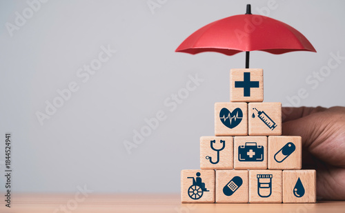 Cuadro en lienzo Wooden blocks with medical icons in a pyramid under a protective umbrella for health insurance life protection medical coverage wellness support safety and long term healthcare security concept